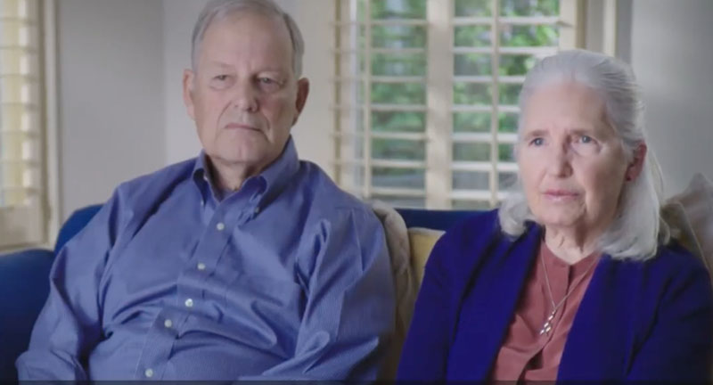 Video still of older couple sitting on a couch